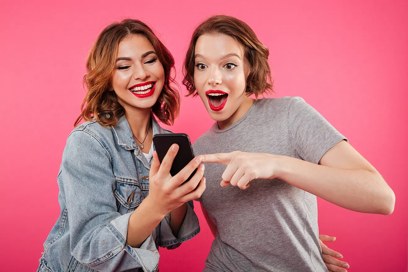 Dwie kobiety przeglądające wspólnie portal randkowy Tinder