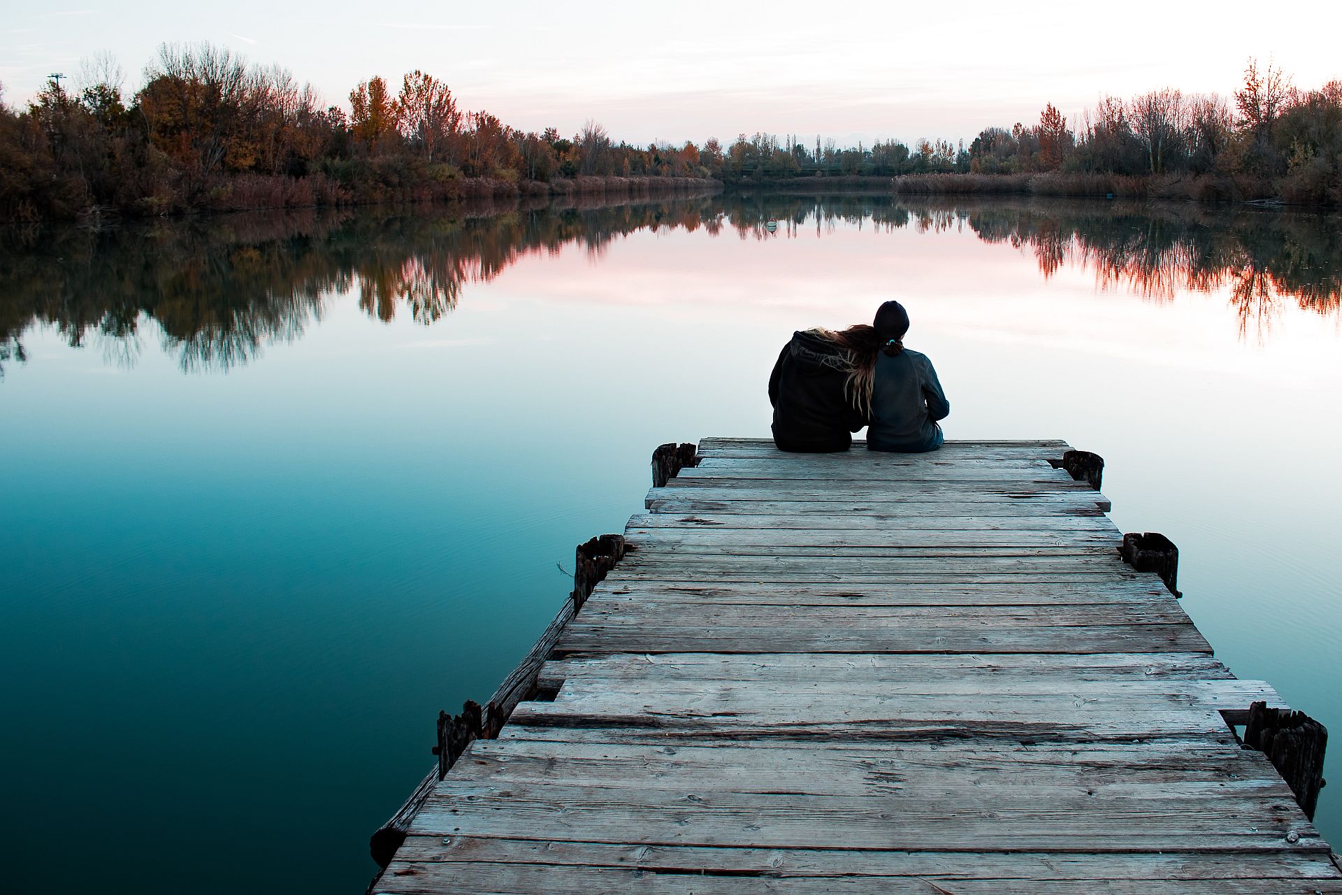 Para siedząca na mostku i rozmawiająca o miłości 