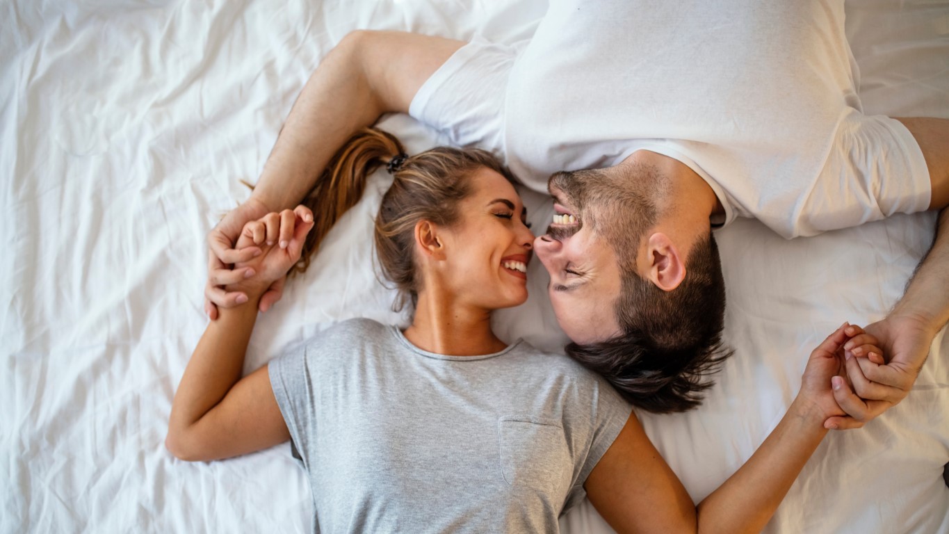 Szczęśliwa zakochana para w łóżku patrząca sobie w oczy 