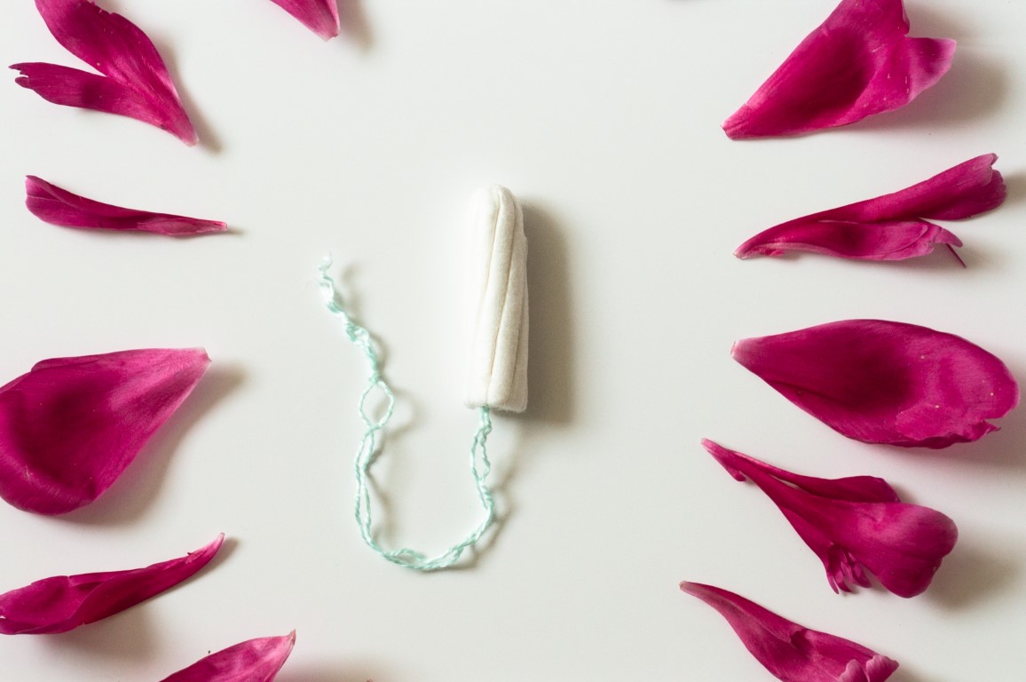 Symbol kobiecości – tampon otoczony płatkami kwiatów