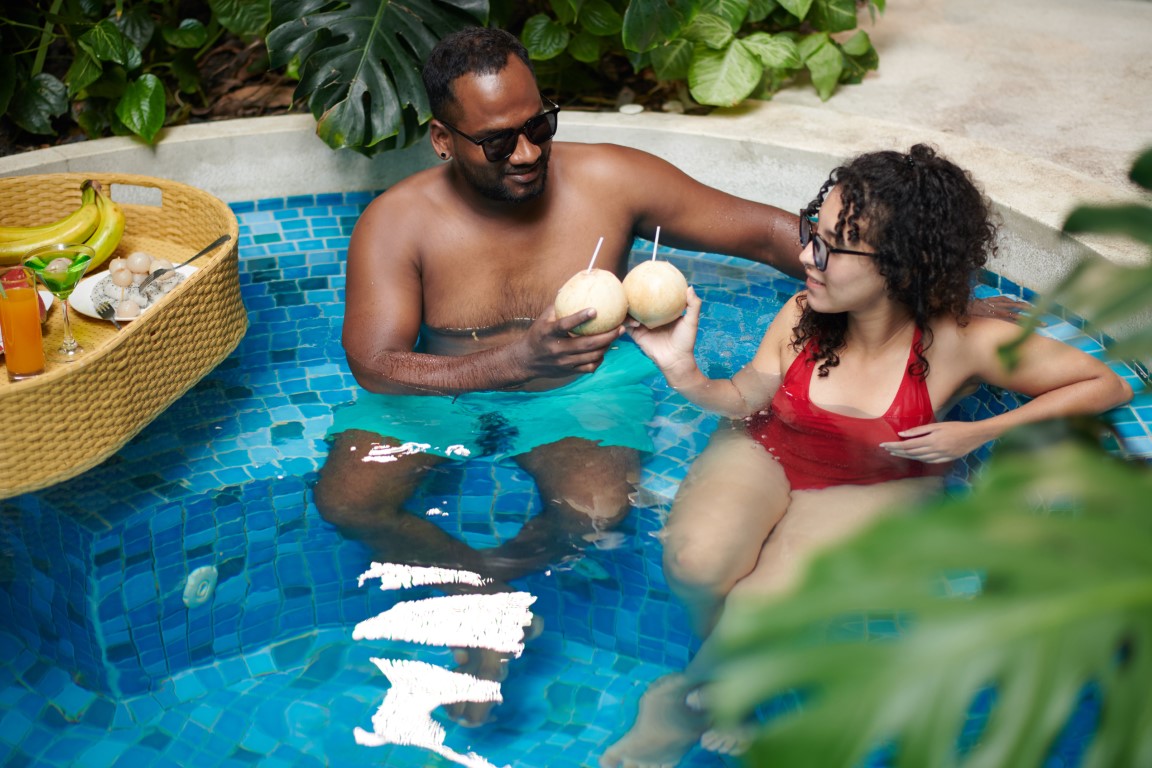 Zrelaksowana para w jacuzzi cieszy się drinkami